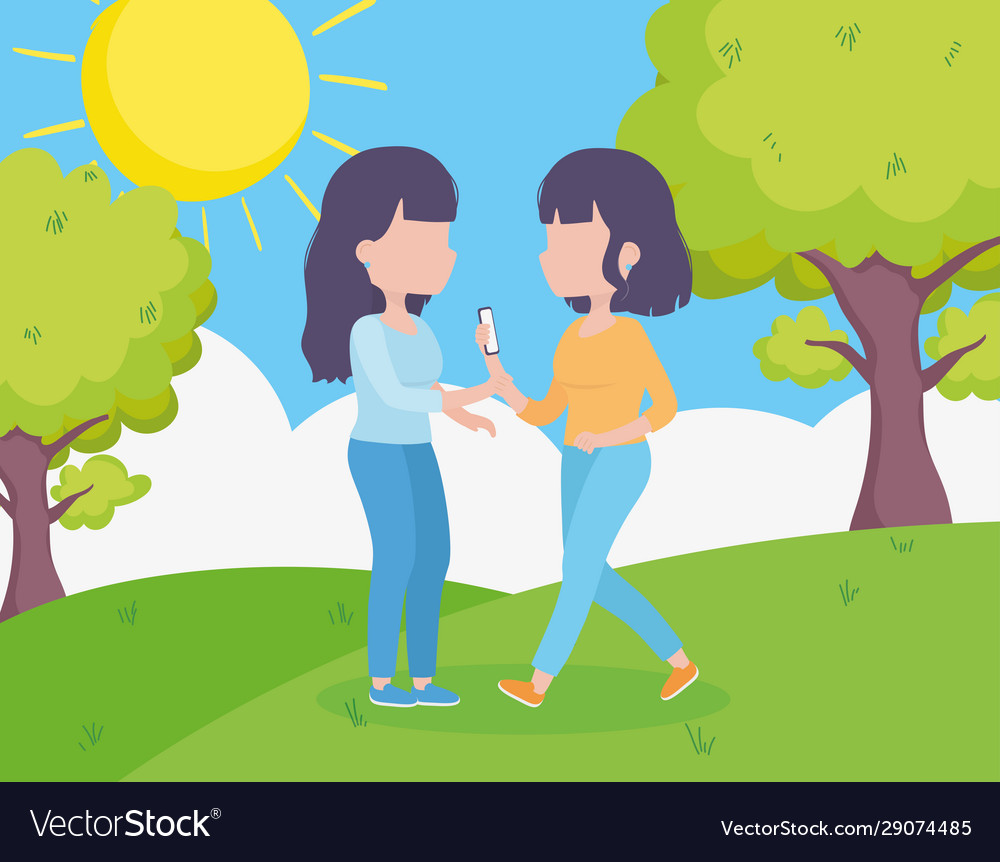 Young women with smartphone together in grass