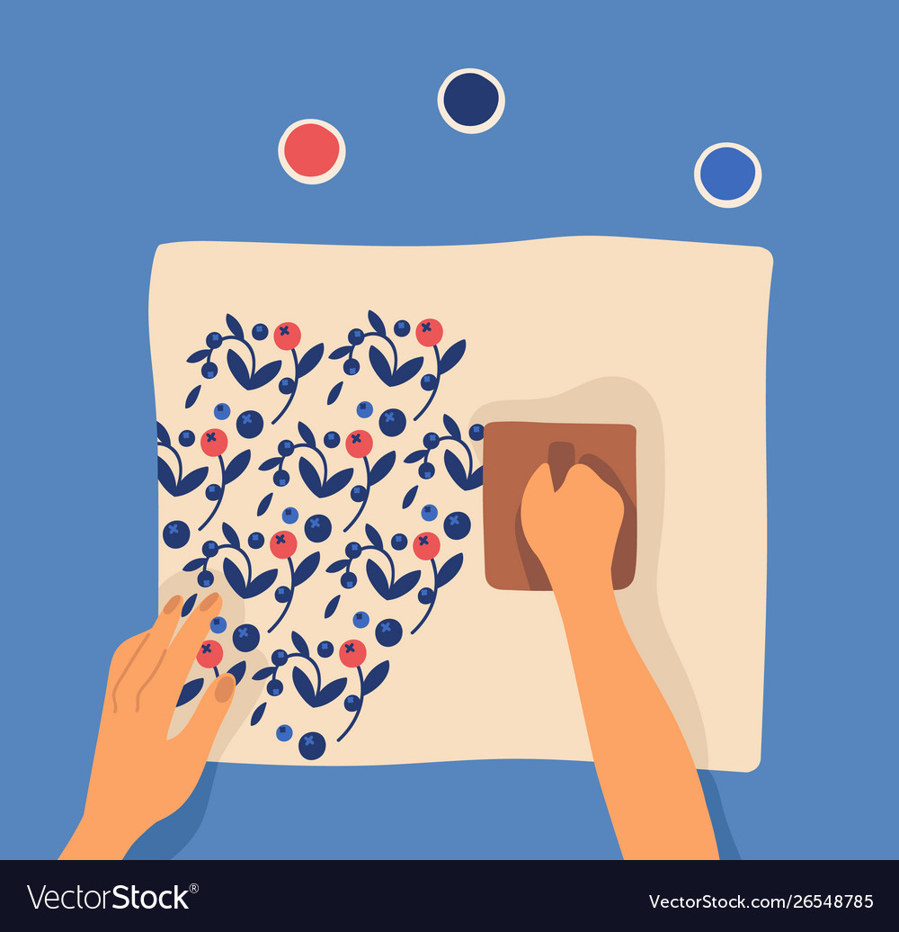 Hands printing pattern on fabric using woodblocks