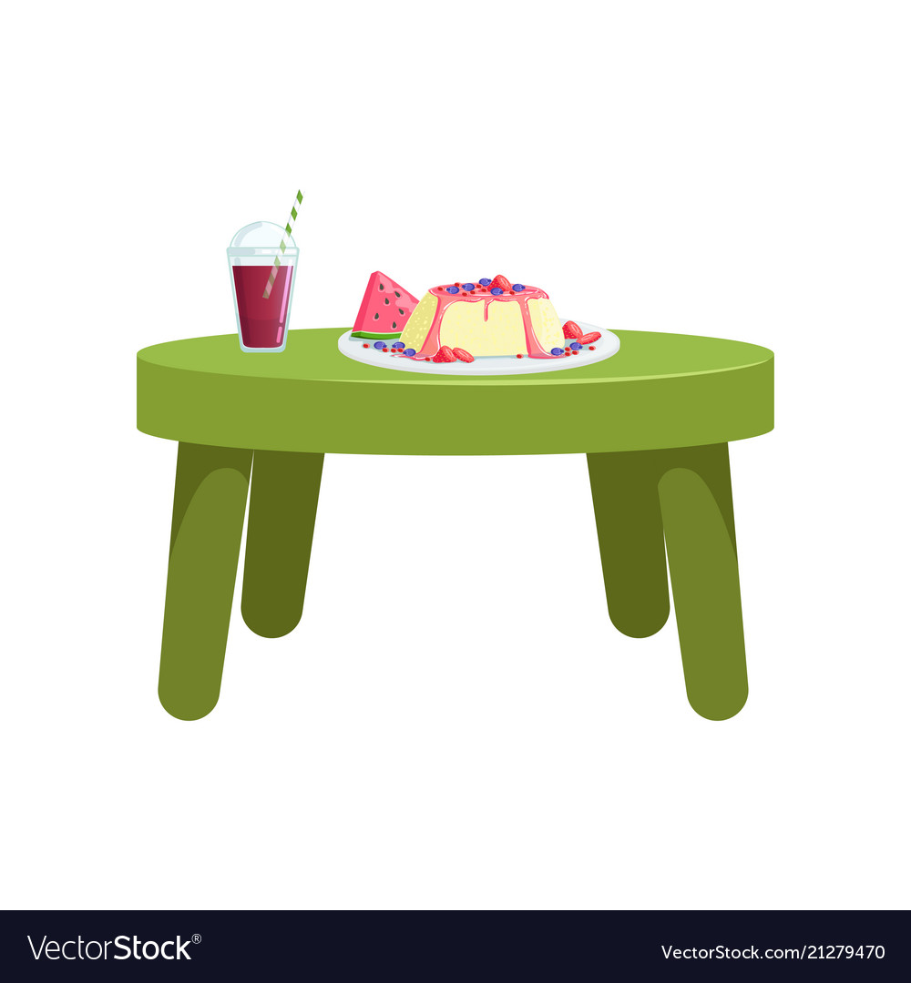 Small green table with glass of juice and a fruit