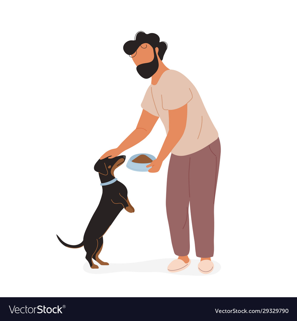 Young man feeding dog and petting on his head